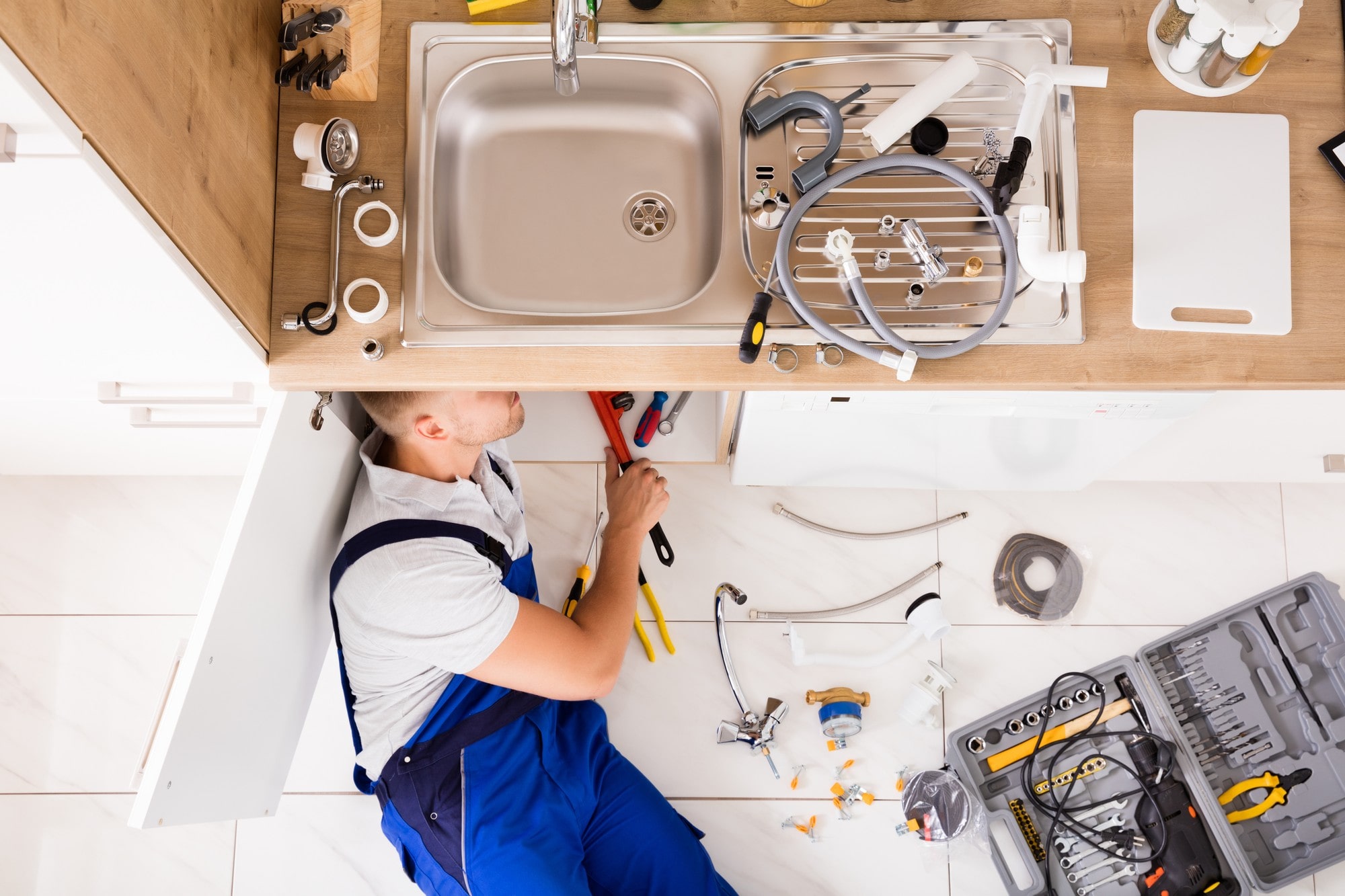 Plumber Working Under The Sink